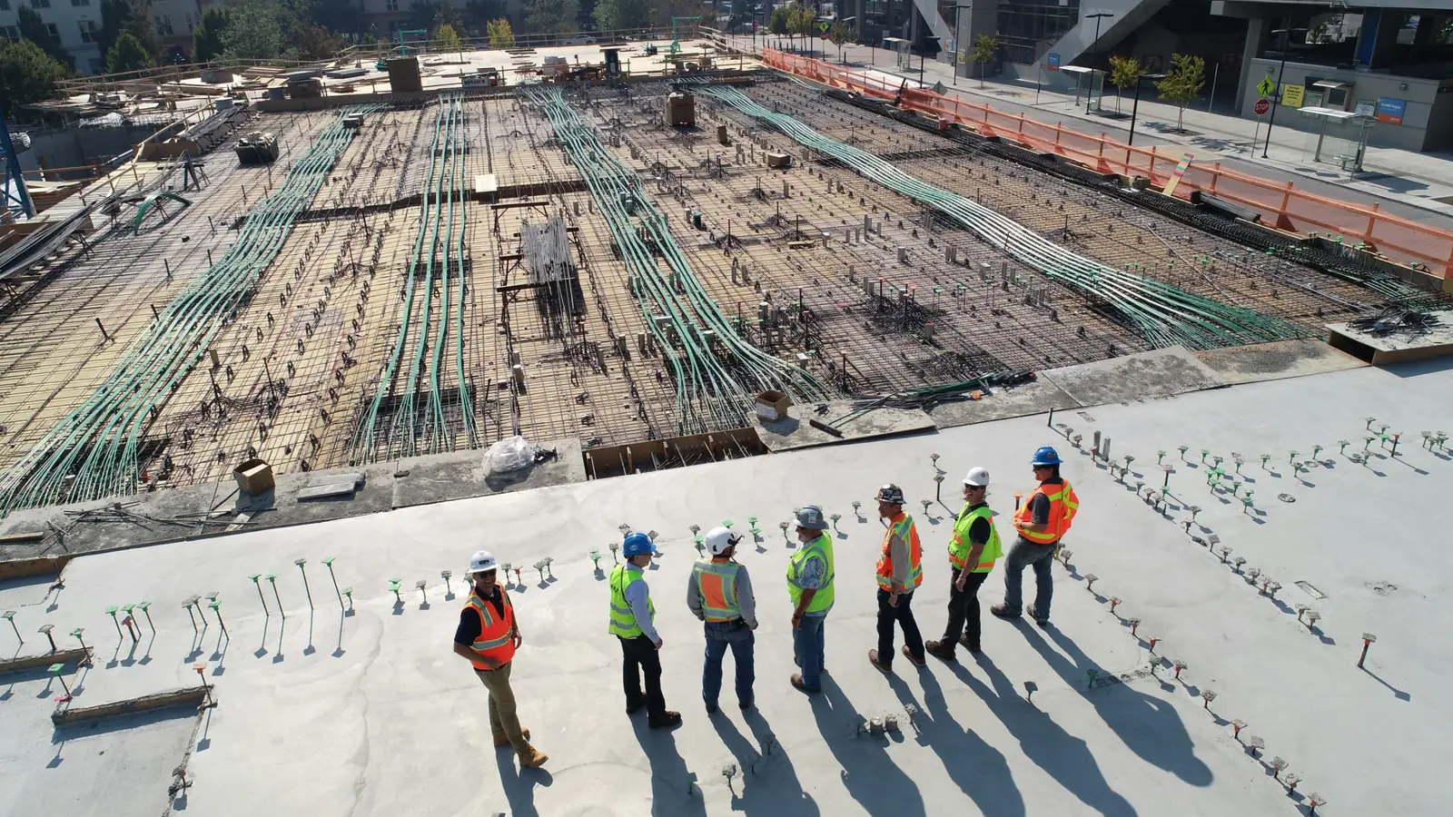 Construction crew in safety vests on a post-tensioned concrete deck