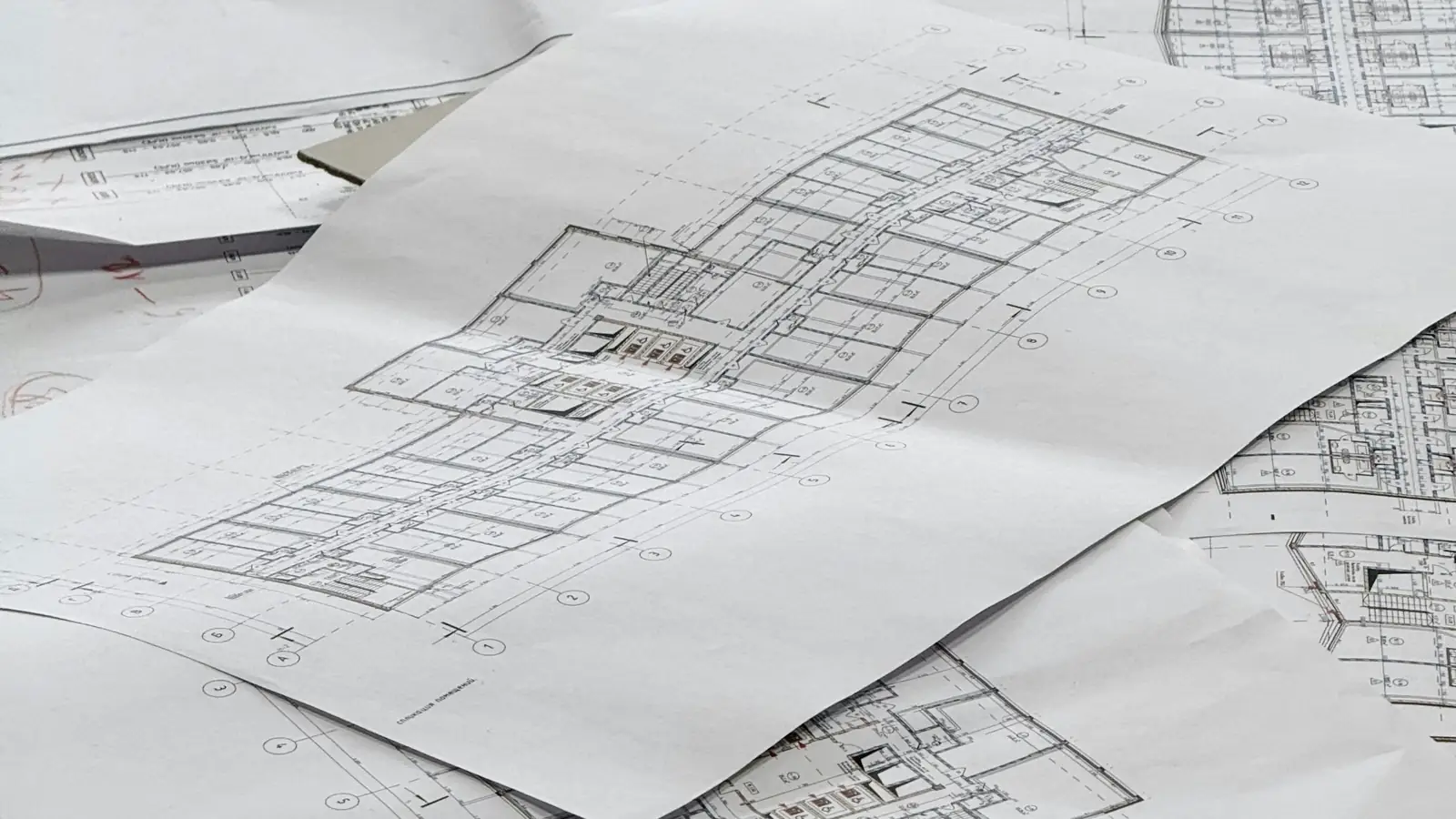 Stack of printed architectural floor plans on a desk